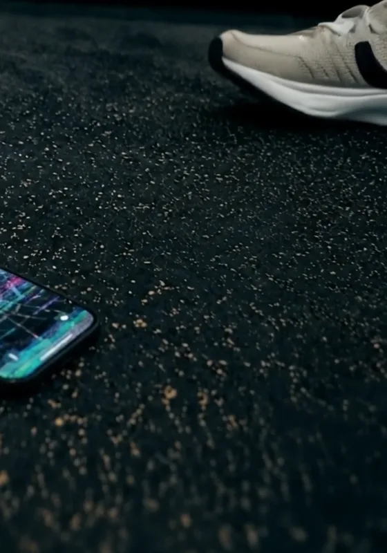 Celular tirado en el pasto junto a un tenis, después de una caída